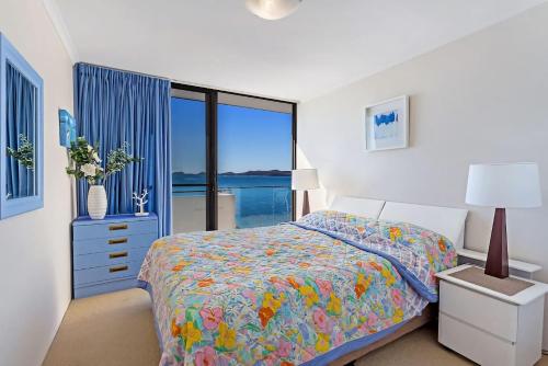 a bedroom with a bed and a large window at Gorgeous Harbourside with Stunning views in Soldiers Point