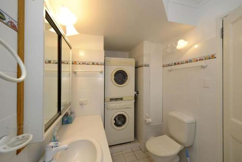 a bathroom with a toilet sink and a washing machine at Gorgeous Harbourside in Soldiers Point