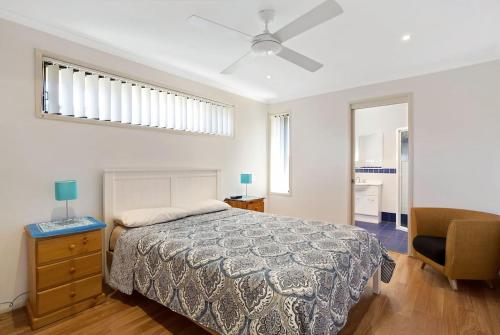 a bedroom with a bed and a ceiling fan at Townhouse in the heart of Port Stephens in Salamander Bay