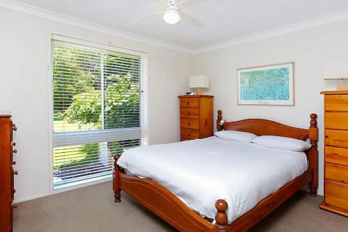 a bedroom with a bed and a large window at Views of Wanda Beach in Salamander Bay