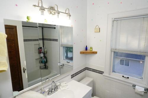 Large North Fargo Home near NDSU في فارغو: حمام أبيض مع حوض ومرآة