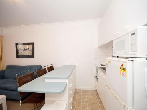 a kitchen with a couch and a table and a refrigerator at Beachside Shoal Bay Unit 6 in Shoal Bay