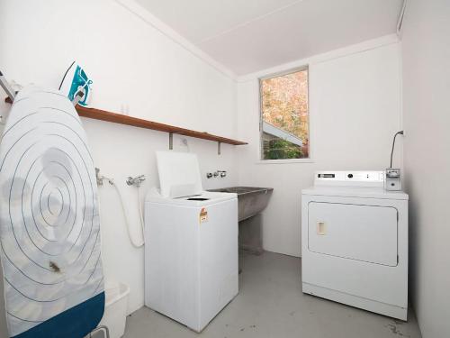 a kitchen with a sink and a washer and dryer at Beachside Shoal Bay Unit 4 in Shoal Bay