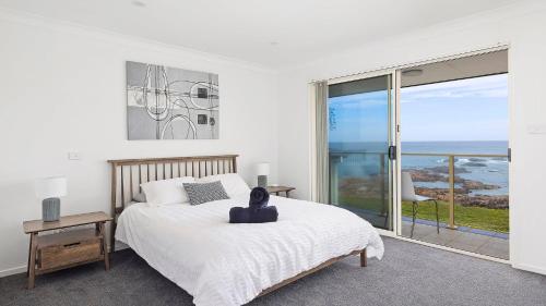a bedroom with a bed with a view of the ocean at Absolute Waterfront Anna Bay in Anna Bay