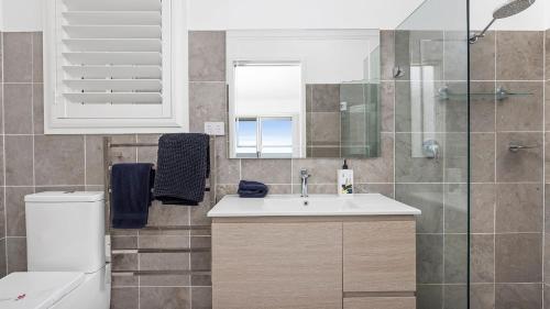a bathroom with a sink and a shower at Absolute Waterfront Anna Bay in Anna Bay