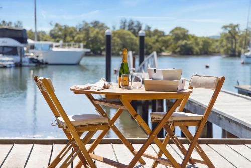 a table with two chairs and a bottle of wine at Skippers Landing in Lemon Tree Passage