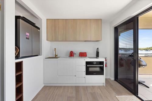 a kitchen with white cabinets and a stove top oven at Skippers Landing in Lemon Tree Passage