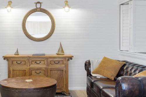 a living room with a leather couch and a table at Skippers Landing in Lemon Tree Passage