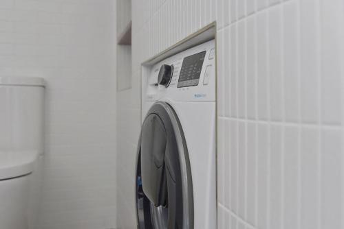 a white washing machine in a white wall at Skippers Landing in Lemon Tree Passage