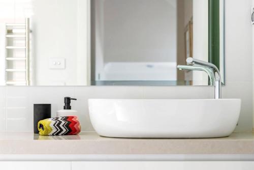 a bathroom counter with a sink and a mirror at Lanimer Spectacular Waterfront in Soldiers Point