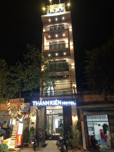 Un palazzo alto con un cartello di fronte a un negozio di Thành Kiên Hotel a Xóm Mỹ Ca