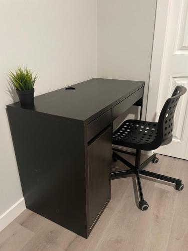 a black desk with a chair in a room at Private Cozy Secondary Suite, 2 Bedrooms, Separate Entrance in Calgary