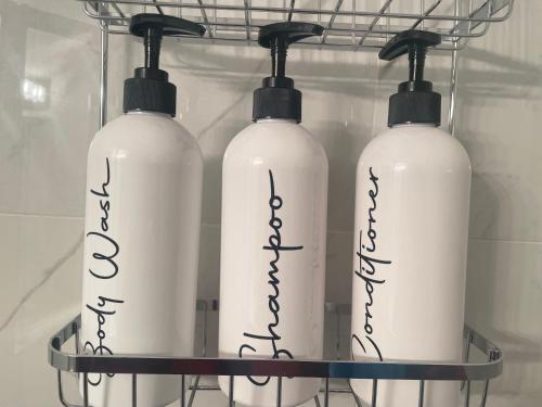 three white bottles on a rack in a refrigerator at Private Cozy Secondary Suite, 2 Bedrooms, Separate Entrance in Calgary