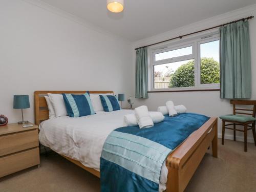 a bedroom with a large bed and a window at Polkerris View in St Austell