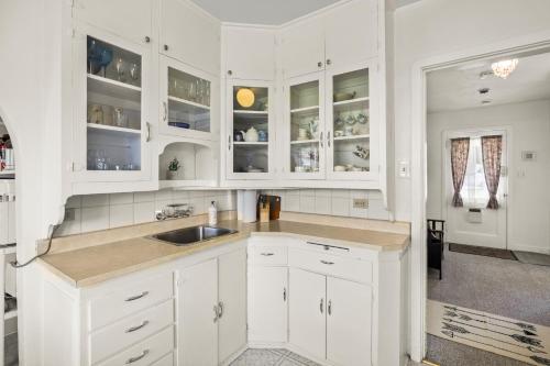 eine weiße Küche mit weißen Schränken und einem Waschbecken in der Unterkunft Coastal Chic Retreat by Iris Properties! in Victoria