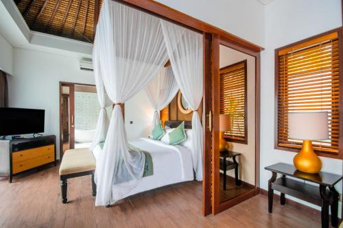 a bedroom with a white bed with a canopy at Lembongan Beach Club & Resort in Nusa Lembongan