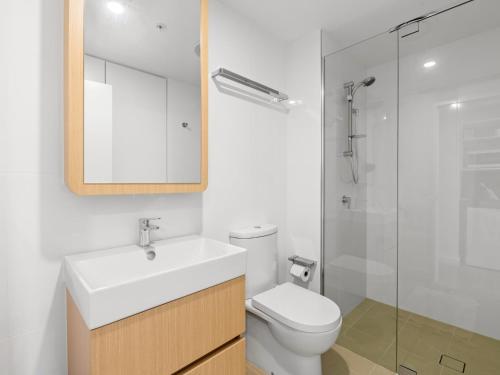 a bathroom with a toilet and a sink and a shower at Brand-New Central Studio Apart with Views in Brisbane