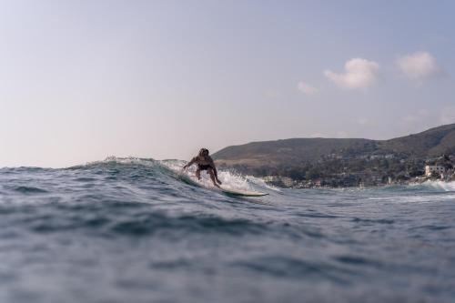 a man riding a wave on a surfboard in the ocean at Laguna Surf Lodge by SCP Hotels in Laguna Beach