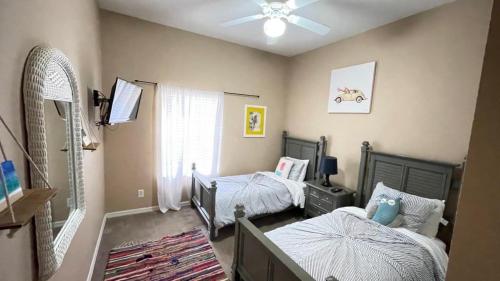 sypialnia z 2 łóżkami pojedynczymi i wentylatorem sufitowym w obiekcie Beautiful 3 Bedroom Apartment minutes from Disney! w mieście Kissimmee