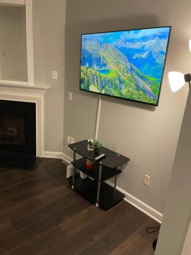 a living room with a table and a painting on the wall at Simple Elegant Townhouse DT Raleigh NCSU in Raleigh
