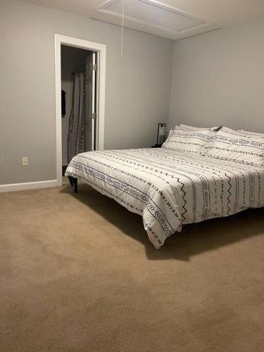 ein Schlafzimmer mit einem Bett mit einer Bettdecke darauf in der Unterkunft Full house charm mins frm DT Raleigh, NC State University in Raleigh