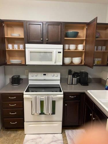 a kitchen with a white stove and a microwave at Simple Elegant Townhouse DT Raleigh NCSU in Raleigh