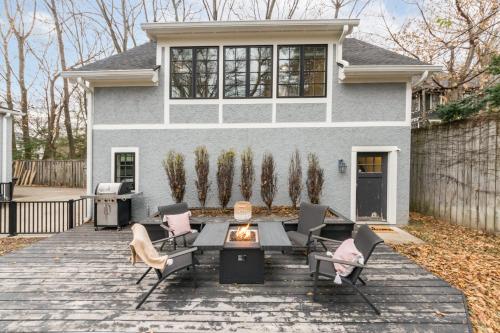 a patio with chairs and a table in front of a house at Modern Tudor Style Carriage House - Patio & grill in Ann Arbor