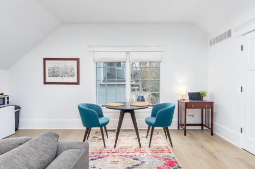 a living room with a table and two blue chairs at Modern Tudor Style Carriage House - Patio & grill in Ann Arbor
