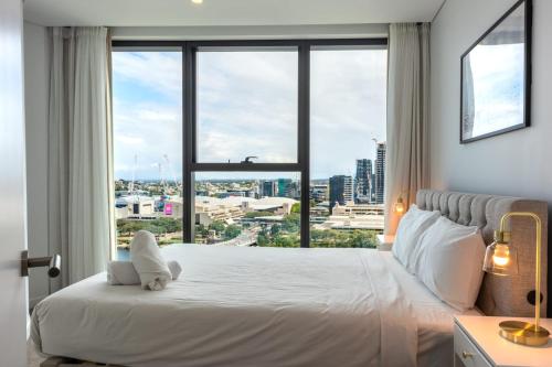 a bedroom with a large window with a teddy bear on a bed at Ultimate Riverview Designer 2BD Apartment at CBD in Brisbane