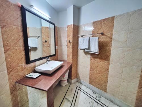 a bathroom with a sink and a mirror at Gagan Resorts in Dharamshala