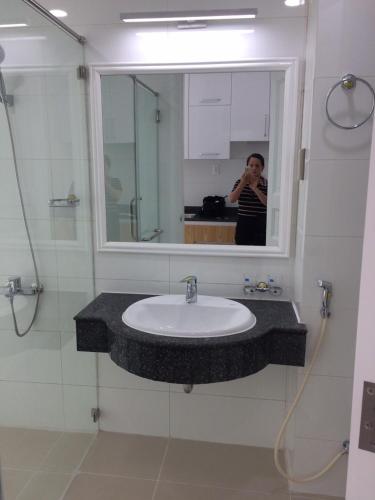 a woman taking a picture of a sink in a bathroom at căn hộ OCEANVISTA in Ấp Phú Tịnh (2)