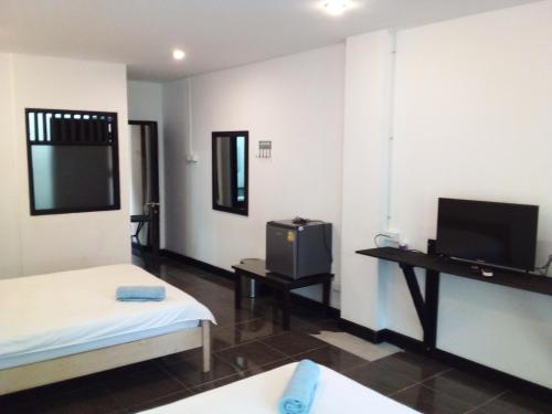 um quarto com duas camas e uma tv nele em FAA Apartment em Vientiane