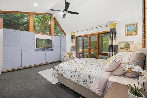 - une chambre avec un lit et un ventilateur de plafond dans l'établissement Sherbrooke Forest Retreat - Noonameena Home, à Sherbrooke