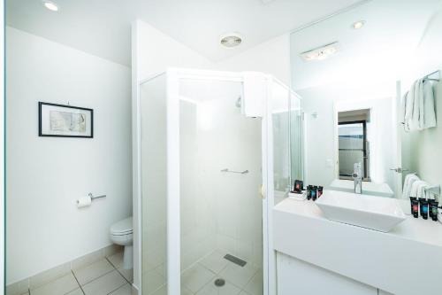 a white bathroom with a shower and a sink at Griffin 184 Kingston Apartment in Kingston 