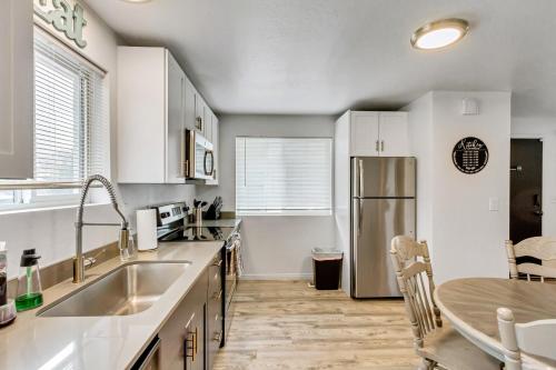 a kitchen with white cabinets and a sink and a table at King bed - Fast Wi-Fi - Walker's Paradise in Salt Lake City