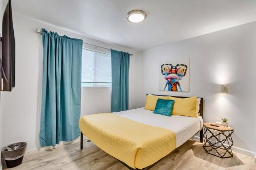 Schlafzimmer mit einem Bett mit gelber Bettwäsche und blauen Vorhängen in der Unterkunft King bed - Fast Wi-Fi - Walker's Paradise in Salt Lake City