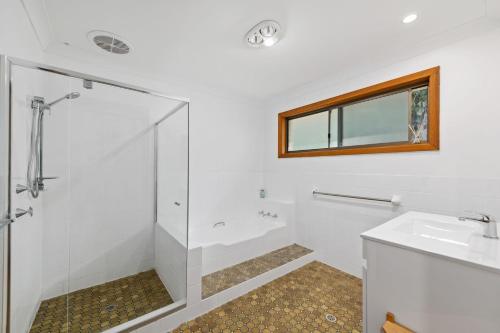 een badkamer met een douche en een wastafel bij Lentara Street 8 in Fingal Bay