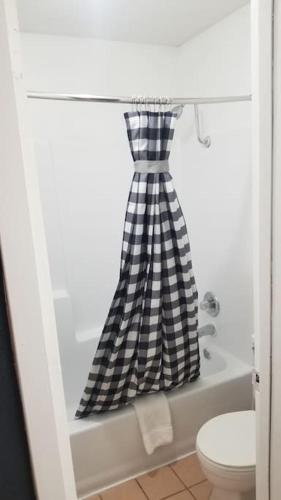 a black and white checkered shower curtain in a bathroom at OSU 2 Queen Beds Hotel Room 224 Hot Tub Booking in Stillwater