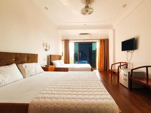 a hotel room with a large bed and a television at Van Thanh Hotel Cua Lo in Cửa Lô