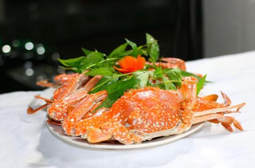 une assiette de nourriture avec des crabes et de la salade sur une table dans l'établissement Van Thanh Hotel Cua Lo, à Cửa Lô