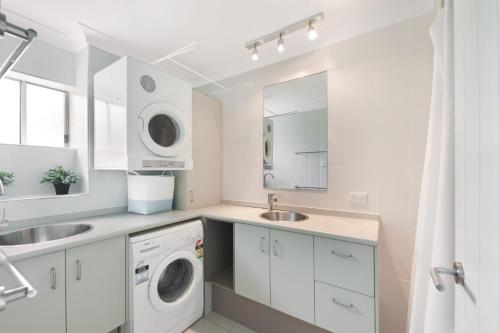 a white laundry room with a washer and dryer at Eagles Retreat Peregian Beach in Peregian Beach