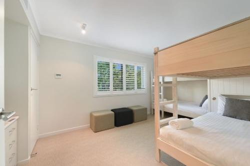 a bedroom with a bunk bed and a window at Eagles Retreat Peregian Beach in Peregian Beach