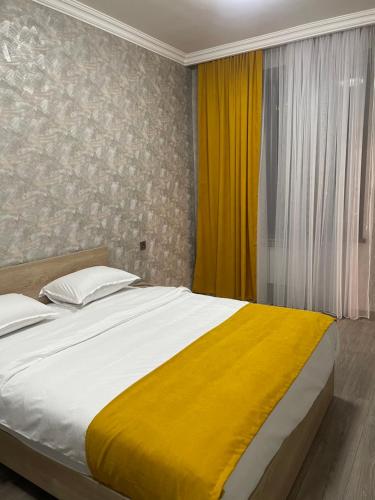 a bedroom with a large bed with a yellow blanket at Apartment in Monument in Yerevan