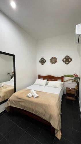 a bedroom with a bed with two towels on it at HOSTEL M&H in Cartagena de Indias