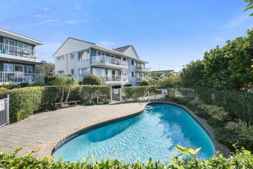 a house with a swimming pool in front of a house at 3 Ocean Shores in Peregian Beach in Peregian Beach
