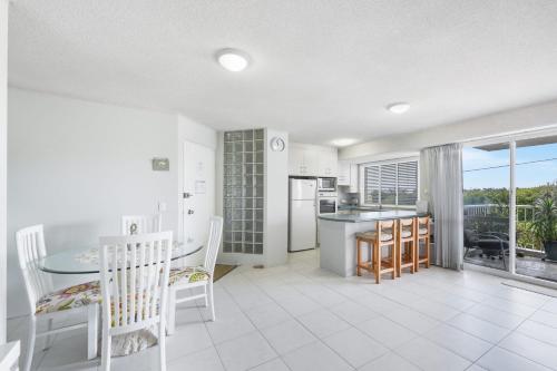 a kitchen and dining room with a table and chairs at 3 Ocean Shores in Peregian Beach in Peregian Beach