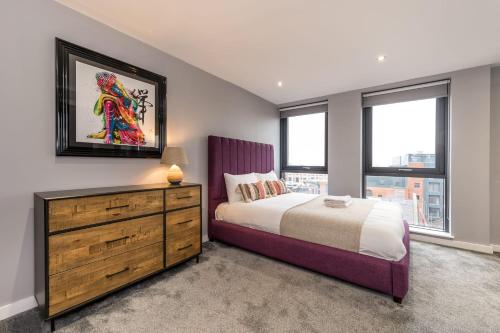 Schlafzimmer mit einem Bett, einer Kommode und Fenstern in der Unterkunft Host & Stay - The Baltic Penthouse 1 in Liverpool
