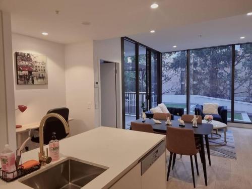 a kitchen and living room with a table and chairs at Sapphire Royale Suite in Macquarie Park in Sydney