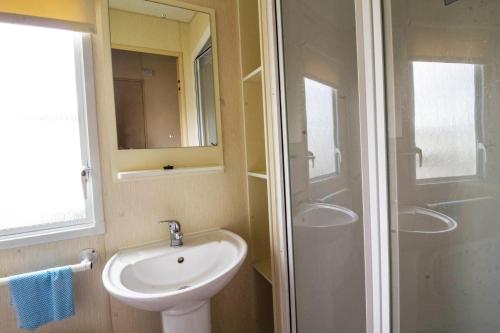 a bathroom with a white sink and a shower at Great 8 Berth Caravan For Hire At Seawick Holiday Park In Essex Ref 27227sw in Clacton-on-Sea