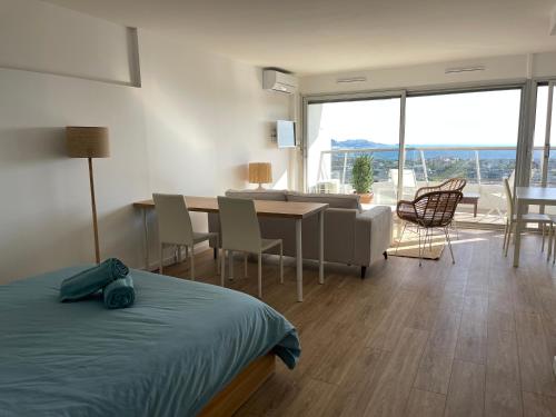 a bedroom with a bed and a living room and a table at Studio vue mer exceptionnelle proche métro et bus in Marseille